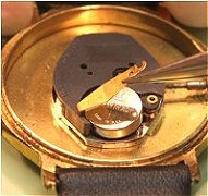 Battery retained by screw clip