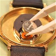 Battery retained by screw clip
